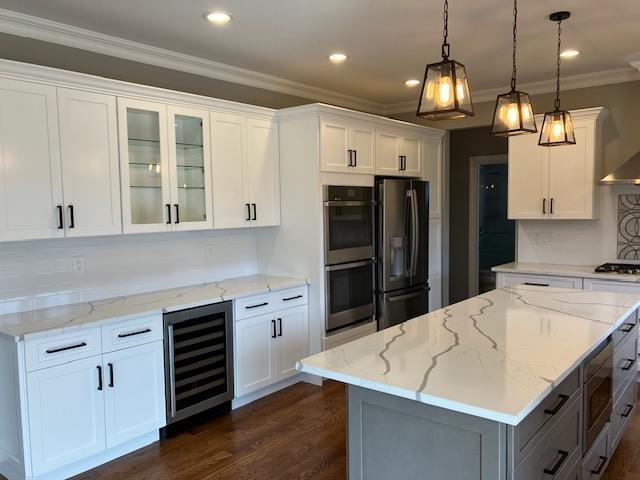 51 Michigan Ave, Massapequa, NY 11758 - kitchen with wine cooler, stainless steel appliances, ornamental molding, white cabinetry, and dark wood-style flooring
