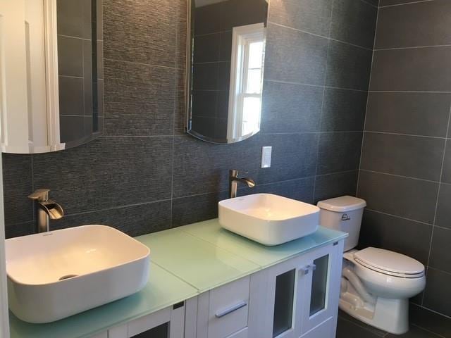 51 Michigan Ave, Massapequa, NY 11758 - bathroom featuring tile walls, tasteful backsplash, double vanity, and toilet