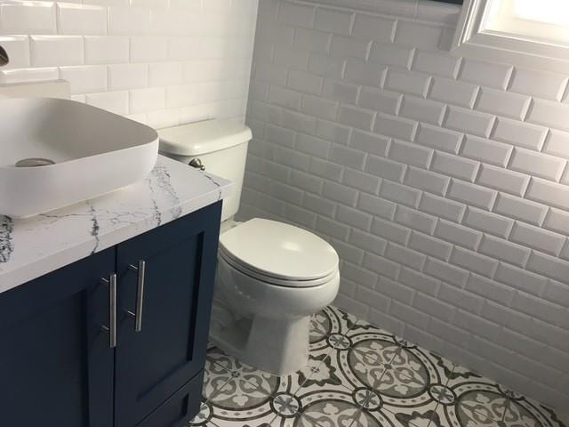 51 Michigan Ave, Massapequa, NY 11758 - bathroom with tile walls, vanity, toilet, and tile patterned floors