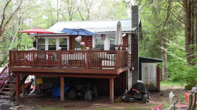 17 W Thompson Pl, Smallwood, NY 12778 - rear view of house with a deck, a carport, a chimney, metal roof, and a forest view