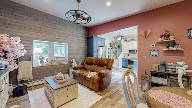 7 Didio Ln, Montgomery, NY 12549 - living area featuring wood walls, light wood finished floors, a baseboard heating unit, recessed lighting, and a chandelier