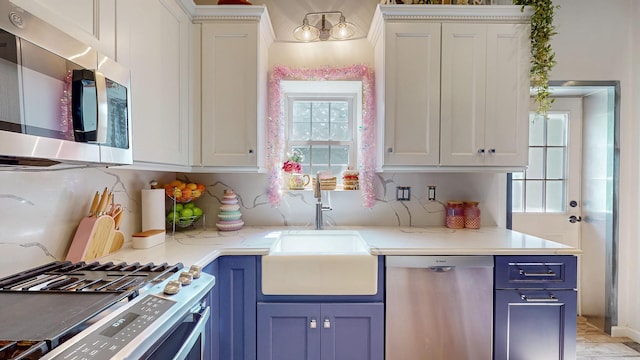 7 Didio Ln, Montgomery, NY 12549 - kitchen featuring appliances with stainless steel finishes, blue cabinetry, white cabinetry, and light stone countertops