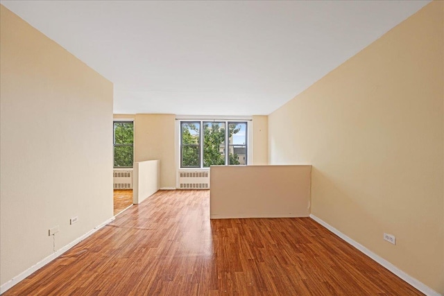 2015 St Paul Ave Unit 3G, Bronx, NY 10461 - empty room with radiator, wood finished floors, and baseboards