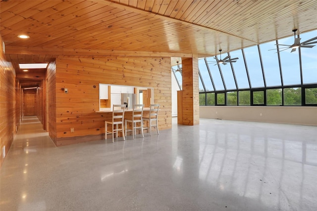 356 Bruyn Tpke, Wallkill, NY 12589 - unfurnished living room featuring wood walls, ceiling fan, and a high ceiling