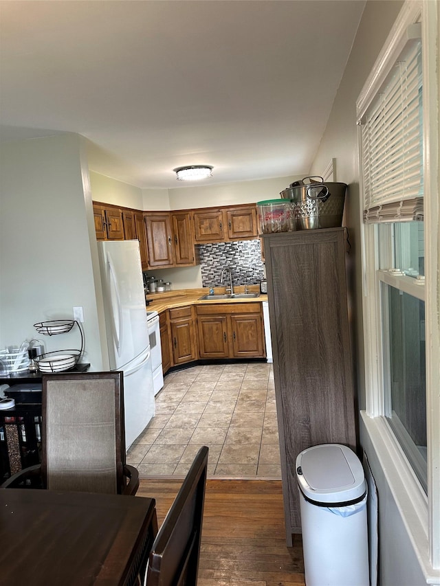 8 Spratt Ave, Poughkeepsie, NY 12603 - kitchen featuring a sink, light countertops, brown cabinetry, white appliances, and light tile patterned floors