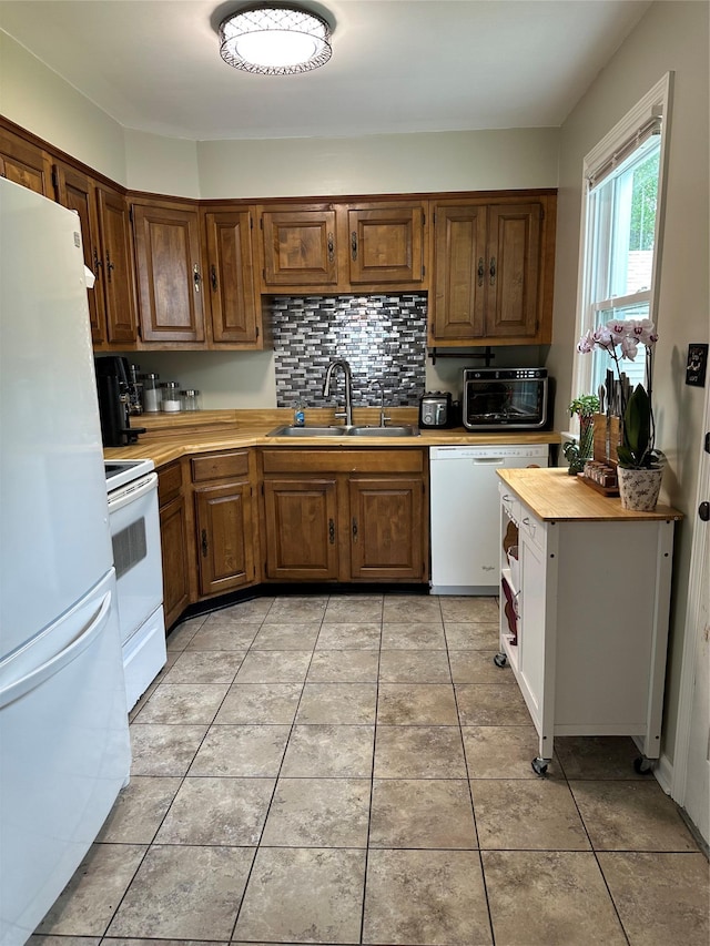 8 Spratt Ave, Poughkeepsie, NY 12603 - kitchen featuring white appliances, a sink, backsplash, brown cabinetry, and light tile patterned flooring