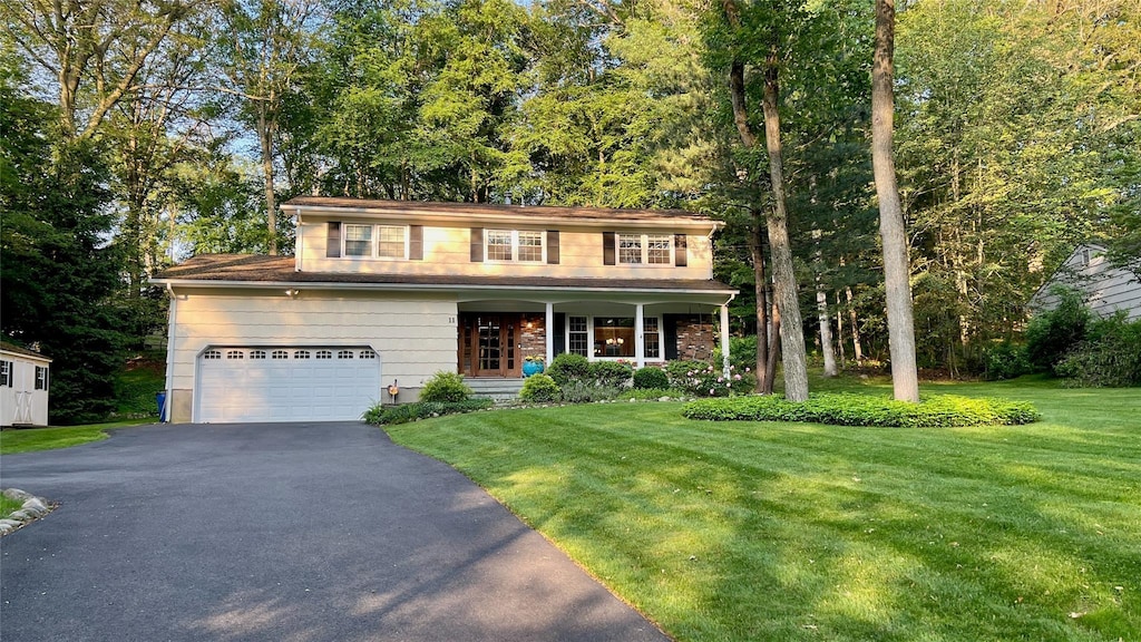 11 Robin Hood Rd, Montebello, NY 10901 - traditional-style house with a porch, driveway, and a front lawn