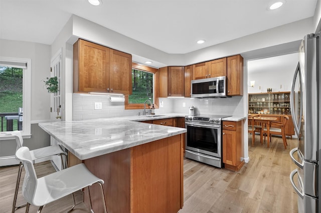11 Robin Hood Rd, Montebello, NY 10901 - kitchen featuring stainless steel appliances, a peninsula, healthy amount of natural light, brown cabinets, and recessed lighting