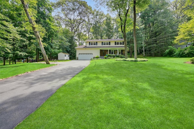 11 Robin Hood Rd, Montebello, NY 10901 - view of front of property featuring driveway, a front yard, a storage unit, and view of wooded area