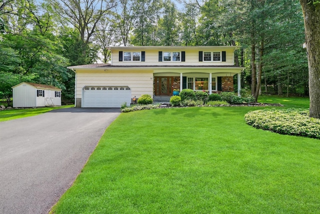 11 Robin Hood Rd, Montebello, NY 10901 - traditional-style house with asphalt driveway, a front lawn, covered porch, a garage, and an outdoor structure