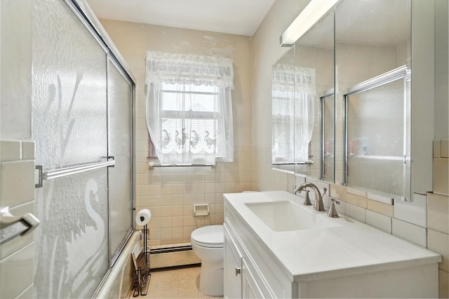 239 Lake St, West Harrison, NY 10604 - full bathroom featuring baseboard heating, tile walls, vanity, bath / shower combo with glass door, and tile patterned floors