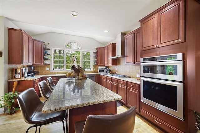 27 Sommerset Dr, Poughkeepsie, NY 12603 - kitchen featuring open shelves, wall chimney exhaust hood, appliances with stainless steel finishes, light stone countertops, and a breakfast bar area