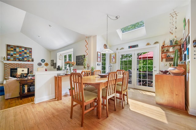 27 Sommerset Dr, Poughkeepsie, NY 12603 - dining room with a skylight, light wood-type flooring, french doors, a brick fireplace, and high vaulted ceiling