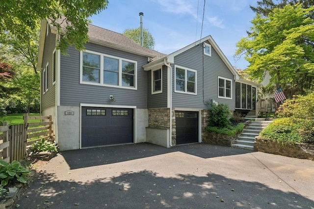 129 W Lakeshore Dr, Carmel, NY 10512 - view of front of home with asphalt driveway, an attached garage, stairway, and a sunroom
