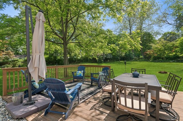129 W Lakeshore Dr, Carmel, NY 10512 - wooden deck with outdoor dining space, a lawn, and view of scattered trees