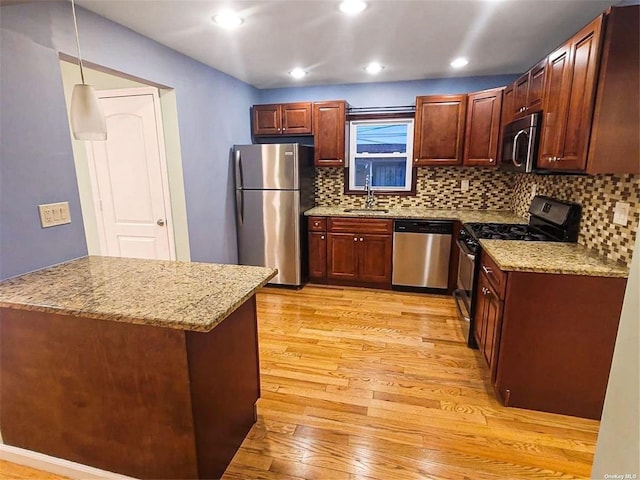 22820 Edgewood Ave, Laurelton, NY 11413 - kitchen with appliances with stainless steel finishes, a sink, light wood-type flooring, backsplash, and light stone countertops