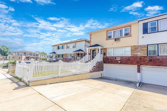 22820 Edgewood Ave, Laurelton, NY 11413 - view of front facade with stucco siding, driveway, an attached garage, and a residential view