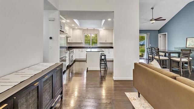 4 Bay View Dr W, Hampton Bays, NY 11946 - kitchen with open floor plan, dark countertops, dark wood-style flooring, white cabinets, and a ceiling fan