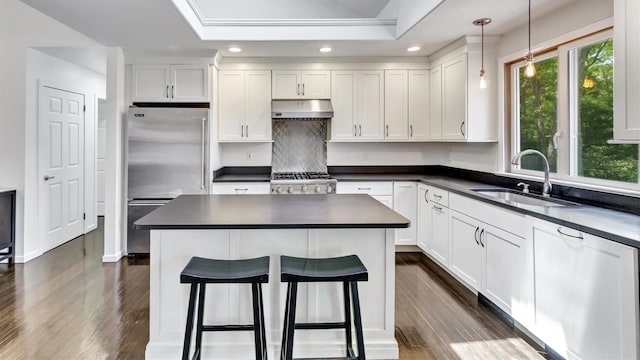 4 Bay View Dr W, Hampton Bays, NY 11946 - kitchen featuring a sink, high end refrigerator, dark countertops, under cabinet range hood, and dark wood-type flooring