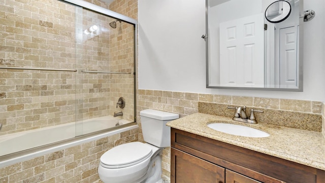 4 Bay View Dr W, Hampton Bays, NY 11946 - bathroom featuring tiled shower / bath, tile walls, toilet, vanity, and a wainscoted wall