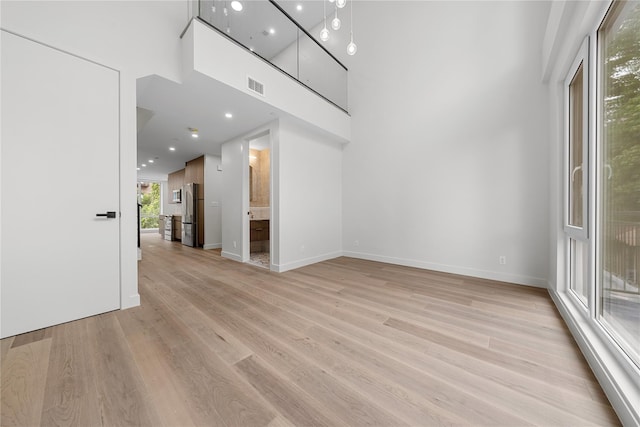 312 Fenimore St, Brooklyn, NY 11225 - unfurnished living room with light wood-type flooring, baseboards, and a high ceiling