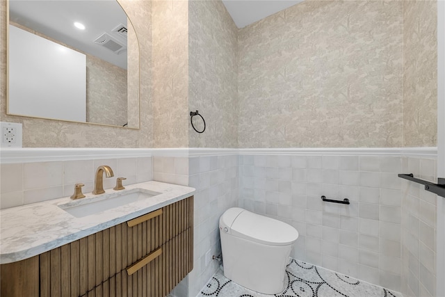 312 Fenimore St, Brooklyn, NY 11225 - bathroom featuring vanity, toilet, a wainscoted wall, tile walls, and tile patterned floors