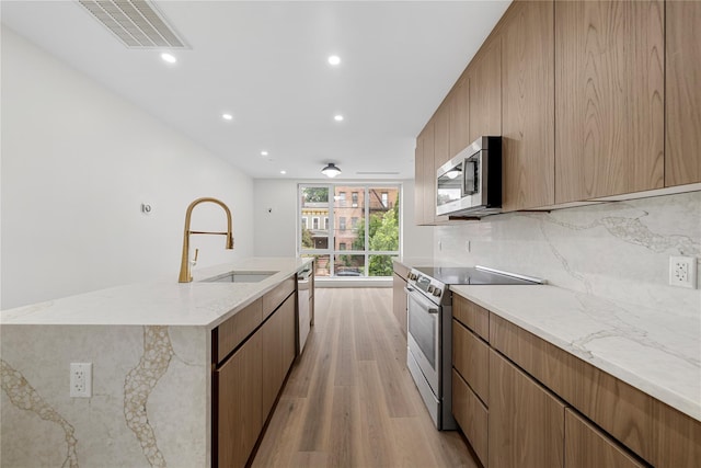 312 Fenimore St, Brooklyn, NY 11225 - kitchen featuring stainless steel appliances, a sink, light wood-style flooring, backsplash, and recessed lighting