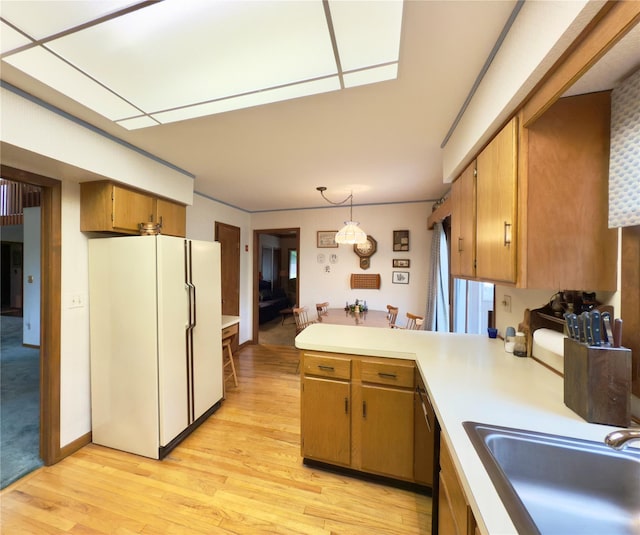 34 Brentwood Dr, Poughkeepsie, NY 12603 - kitchen featuring freestanding refrigerator, a sink, light wood-style floors, a peninsula, and light countertops