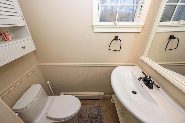 7 Daniel Ct, Lake Ronkonkoma, NY 11779 - bathroom with baseboard heating, vanity, wainscoting, toilet, and a decorative wall