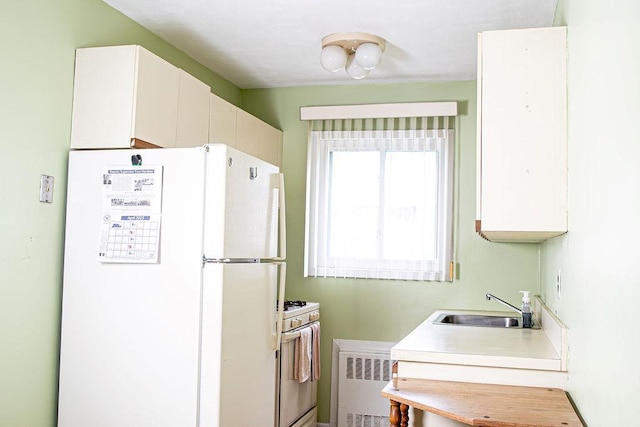 182 Edmunton Dr Unit D3, North Babylon, NY 11703 - kitchen featuring white appliances, a sink, radiator heating unit, white cabinets, and light countertops