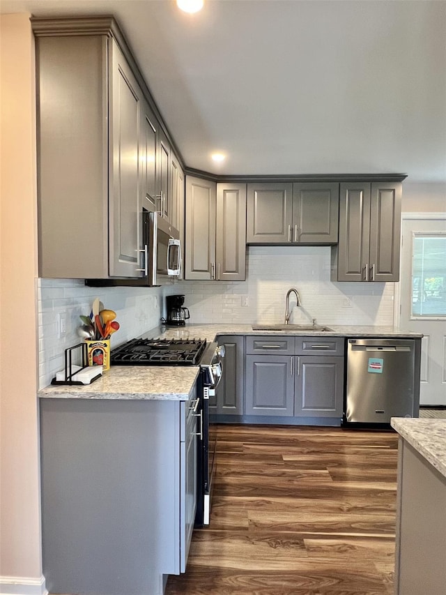 7 Mindy Ln, Jericho, NY 11590 - kitchen featuring appliances with stainless steel finishes, gray cabinetry, dark wood finished floors, backsplash, and light stone countertops