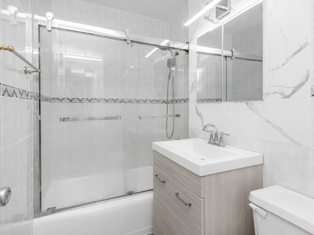 5900 Arlington Ave Unit 6S, Bronx, NY 10471 - bathroom featuring tile walls, bath / shower combo with glass door, toilet, vanity, and tasteful backsplash