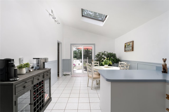 14FELWAYDRIVE Felway Dr Unit 14, Coram, NY 11727 - kitchen featuring vaulted ceiling, a skylight, a wainscoted wall, light tile patterned flooring, and a peninsula