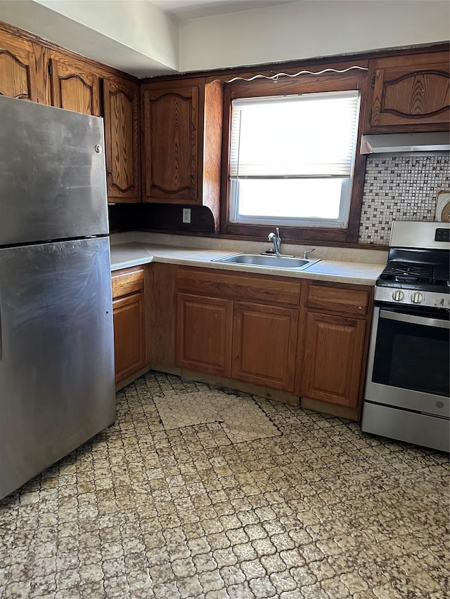 50 Mahland Pl, Oceanside, NY 11572 - kitchen featuring appliances with stainless steel finishes, a sink, light countertops, brown cabinets, and range hood
