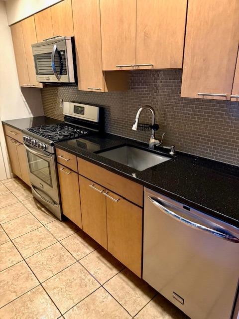 1010 Washington Grn Unit 1010, New Windsor, NY 1255312553 - kitchen featuring appliances with stainless steel finishes, backsplash, light tile patterned flooring, and dark stone counters