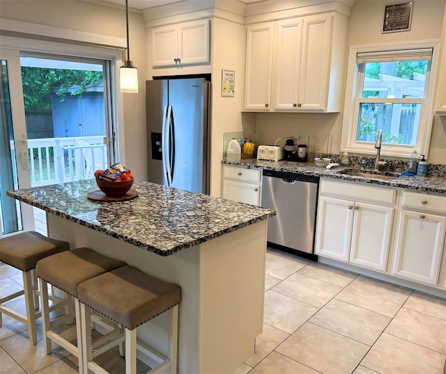 1 Roberta St, East Patchogue, NY 11772 - kitchen featuring appliances with stainless steel finishes, white cabinetry, light tile patterned floors, and dark stone countertops