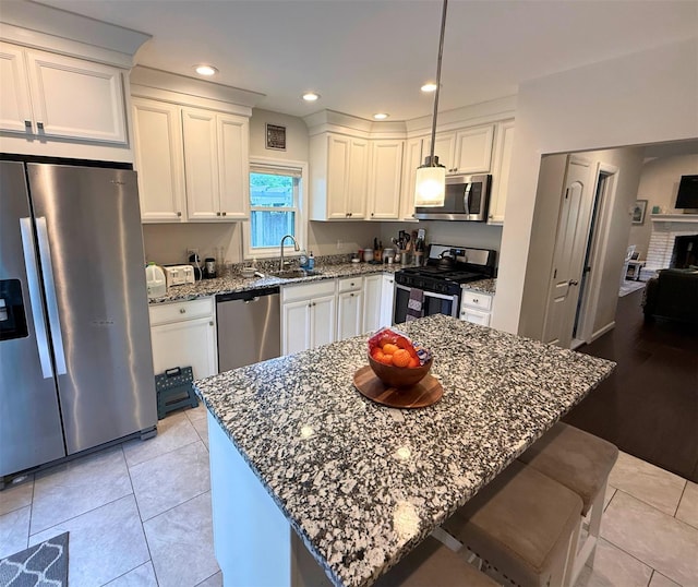 1 Roberta St, East Patchogue, NY 11772 - kitchen featuring stainless steel appliances, dark stone counters, white cabinets, a sink, and recessed lighting