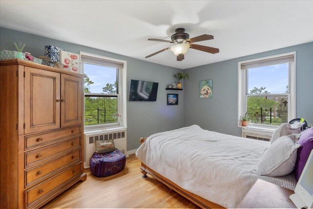 209-80 18th Ave Unit 4D, Bayside, NY 11360 - bedroom featuring radiator, light wood-style floors, and ceiling fan