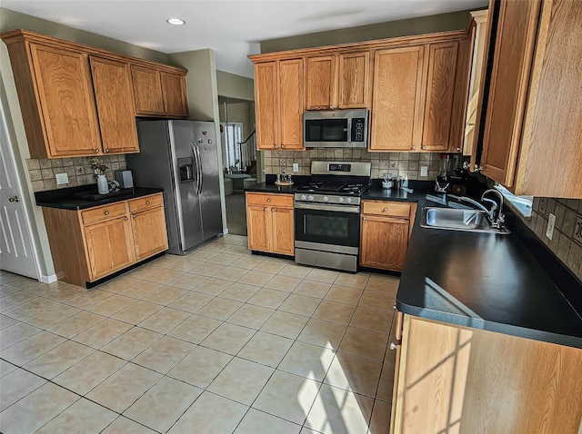 2717 Colonial Dr, New Windsor, NY 12553 - kitchen with stainless steel appliances, a sink, decorative backsplash, dark countertops, and light tile patterned floors