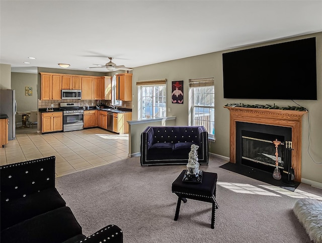 2717 Colonial Dr, New Windsor, NY 12553 - living area with light colored carpet, a fireplace with flush hearth, a ceiling fan, light tile patterned floors, and baseboards
