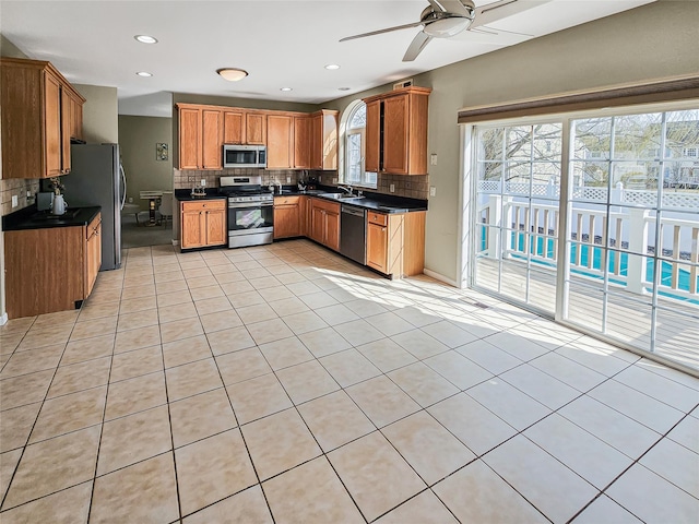 2717 Colonial Dr, New Windsor, NY 12553 - kitchen with appliances with stainless steel finishes, dark countertops, a sink, tasteful backsplash, and a ceiling fan
