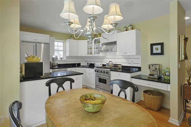 17 Deer Tree Ln, Briarcliff Manor, NY 10510 - kitchen featuring high end appliances, under cabinet range hood, dark countertops, white cabinetry, and glass insert cabinets