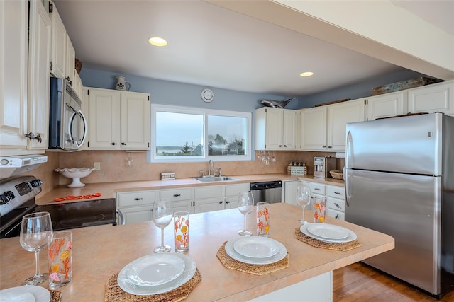 19 Cold Spring Ct, Southampton, NY 11968 - kitchen featuring appliances with stainless steel finishes, light countertops, white cabinets, recessed lighting, and light wood finished floors