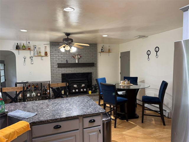 77 Upper Rd, Bloomingburg, NY 10940 - kitchen with a ceiling fan, a brick fireplace, baseboard heating, freestanding refrigerator, and light wood-style floors
