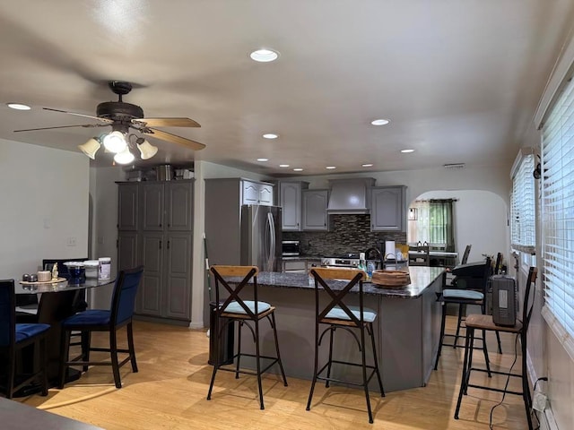 77 Upper Rd, Bloomingburg, NY 10940 - kitchen featuring freestanding refrigerator, a kitchen bar, wall chimney exhaust hood, a ceiling fan, and recessed lighting