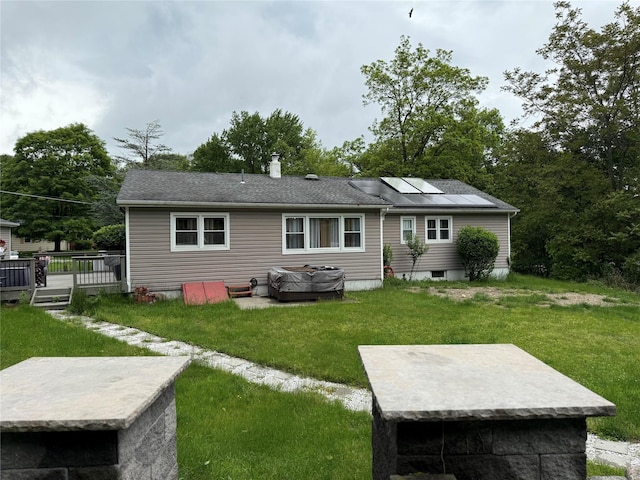 77 Upper Rd, Bloomingburg, NY 10940 - rear view of house featuring roof mounted solar panels, a lawn, a wooden deck, and a chimney