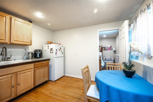 929 Fox Meadow Rd, Yorktown Heights, NY 10598 - kitchen featuring freestanding refrigerator, a sink, light wood-style floors, a textured ceiling, and dark countertops