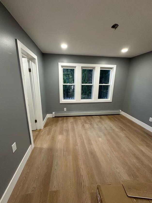 123 Mitchell St, North Bellmore, NY 11710 - unfurnished room with wood finished floors, baseboards, baseboard heating, and recessed lighting