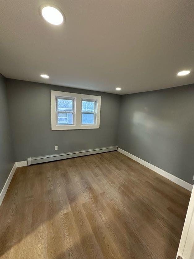 123 Mitchell St, North Bellmore, NY 11710 - unfurnished room with baseboards, wood finished floors, a baseboard radiator, and recessed lighting