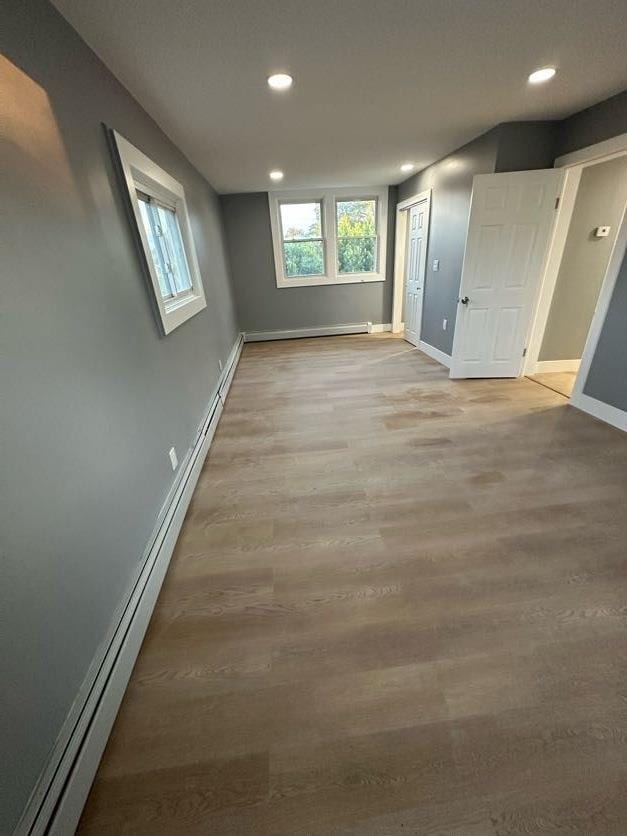 123 Mitchell St, North Bellmore, NY 11710 - spare room featuring a baseboard heating unit, baseboards, recessed lighting, light wood-style flooring, and a baseboard radiator